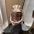 Leopard print box handbag with pearl handle, drawstring liner, and gold chain strap - Brown