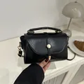 Minimalistische schwarze Umhängetasche aus glänzendem Leder mit goldener Metallschnalle - Schwarz