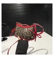 Detailansicht der Leoparden-Handtasche mit roten Lacklederschleifen und Metallnieten - Rot