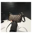 Detail der Schultertasche mit Leopardenmuster, schwarzem Lackbesatz und Goldakzenten - Schwarz