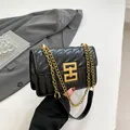 Borsa a spalla trapuntata nera con catena dorata e chiusura geometrica elegante - Nero