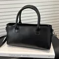 Minimalistische zwarte vierkante crossbodytas met cilindrische handgrepen en reliëf - Zwart