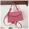 Detail of pink woven square handbag featuring a unique braided rope handle and knot - Pink