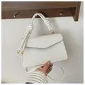Detail of white woven leather handbag featuring a decorative handle knot and gold hardware - White
