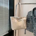 Beigefarbene Stroh-Tote-Bag mit zarter Spitzenschleife und weißen Ledergriffen für Damen - Weiß