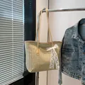 Sommerliche Strohtasche mit Lederriemen und einer großen weißen Spitzenschleife am Rand - Khaki