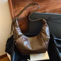Deep brown leather croissant bag with knotted shoulder strap in a stylish moon shape - Brown