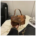 Detail van vintage bruine handtas met slangenpatroon, gouden ketting en hard handvat - Bruin