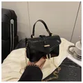 Detail van zwarte mini-tas met slangenpatroon goudkleurige ketting en gesp - Zwart