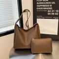 Minimalist dark brown tote bag set with matching zipper pouch on a metal table - Brown