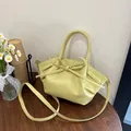 Elegante bolso de mano amarillo pálido con lazo decorativo y textura plisada suave - Amarillo