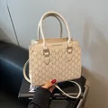 Bolso tote crema elegante con estampado de monograma M y herrajes dorados en revista - Blanco Roto