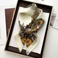 Detailansicht eines seidigen Seidentuchs mit Vintage-Blumenmuster in einer Geschenkbox - Milchweiß