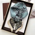 Detailed view of gray-blue floral silk scarf with sketch pattern in a leather tray - Sky Blue