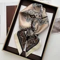 Detailed view of champagne floral silk scarf elegantly folded inside a premium gift box - Coffee