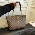 Bolso tote marrón con monograma, asas de cadena dorada y un pequeño colgante de ciervo - Marrón