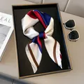 Elegant geometric square silk scarf with red and navy color blocks on a beige tray - Coffee