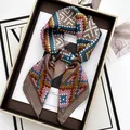 Pink and gold geometric print silk scarf folded in a black gift box on magazine - Khaki Pink