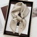 Detail of silk scarf with seagull print on elegant tray over high-end magazine - Khaki