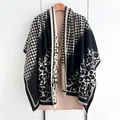 Detailed view of leopard print and houndstooth pattern patchwork on warm thick shawl - Black