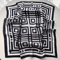 Vue détaillée des motifs géométriques rayés sur un carré de soie de luxe pour femme - 65x65cm / Noir