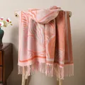 Detail of pink and orange knit shawl with leaf patterns and thick tassel fringe - Pink