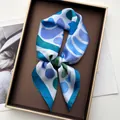Detailed view of geometric blue silk scarf in a premium gold-trimmed gift box - Sky Blue