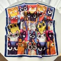 Detail view of the colorful pop art cat print and navy hem on a soft square silk scarf - Blue