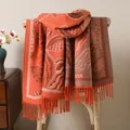 Detailed close-up of orange ethnic jacquard shawl with intricate fringes and patterns - Orange