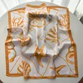 Detailed close-up showing the smooth satin texture and ocean starfish print on the silk scarf - Yellow