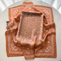 Detail of vintage terracotta silk scarf with white mandala print on a white surface - Chocolate