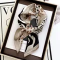 Elegant leopard print silk scarf with geometric stripes on luxury magazine background - Khaki