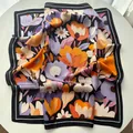 Vue détaillée du foulard carré en satin de soie fleuri montrant la texture douce - Noir Orange Violet Contraste Floral (29)