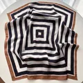 Close-up of a striped silk neckerchief with brown and navy blue geometric patterns - Black