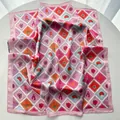 Detail of a square silk scarf with tropical stamps, palm trees and hibiscus flowers - Pink