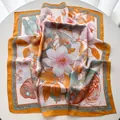 Detail of silk-like floral scarf showing magnolia print and luxury smooth texture - 65x65cm / Orange Red
