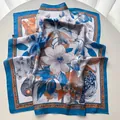 Detailed macro view of magnolia floral print silk scarf with luxury blue and orange borders - 65x65cm / Blue