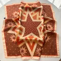 Caramel silk square scarf featuring star patterns and polka dots on a white table - Coffee