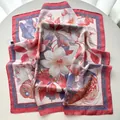 Close-up of silk scarf featuring magnolia floral print and pomegranate patterns - 65x65cm / Pink