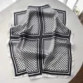 Macro detail of silk-like square scarf featuring retro black and white polka dot pattern - White