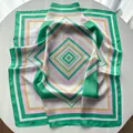 Green and pink geometric pattern silk scarf with elegant satin finish on white surface - Green