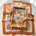 Detail of floral magnolia print silk scarf with luxury orange borders and satin texture - 65x65cm / Khaki