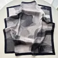 Elegant black and white abstract mountain print silk scarf displayed on a pedestal - Black