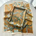 Close-up of a yellow silk scarf featuring Van Gogh almond blossom floral print texture - Khaki