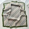 Detalle de pañuelo cuadrado de satén con estampados ondulados verdes y borde suave - Verde