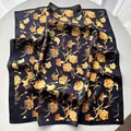 Elegant black silk square scarf featuring vibrant orange and yellow carnation flower prints - Black