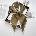 Detail of elegant zebra print silk scarf tied in a bow on a vintage olive green fabric - Earthy Yellow