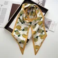 Vue détaillée du motif citron sur élégant foulard twilly en satin de soie blanc - Jaune Citron
