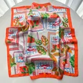Detailansicht des lebhaften Orangen- und Tropenblattmusters auf dem Seidenschal aus Satin - 65x65cm / Orangerot