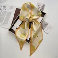 Detailed shot of yellow twilly scarf featuring hand-drawn durian prints and a neat bow knot - Lemon Yellow
